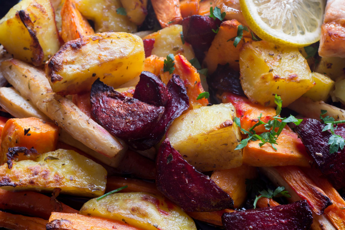 Roasted beats, potatoes and carrots with lemon slices and herbs