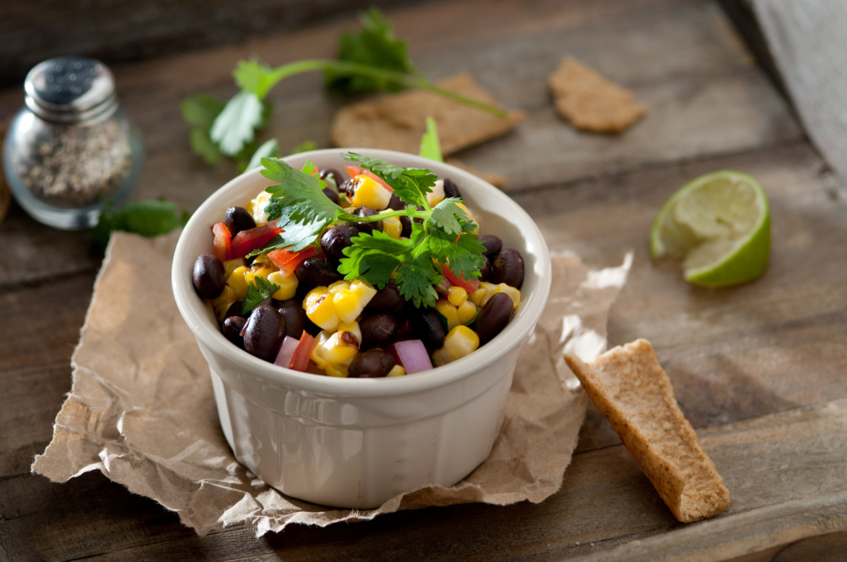 A bowl of salsa with beans, corn, onion and cilantro