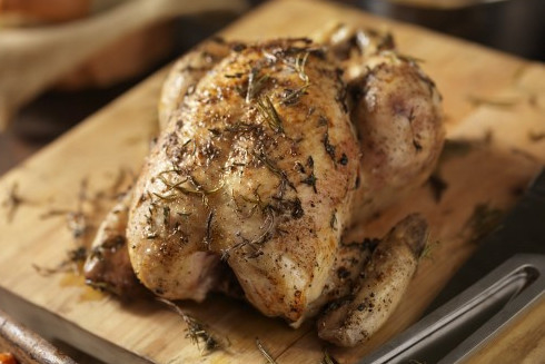 A whole roast chicken on a cutting board