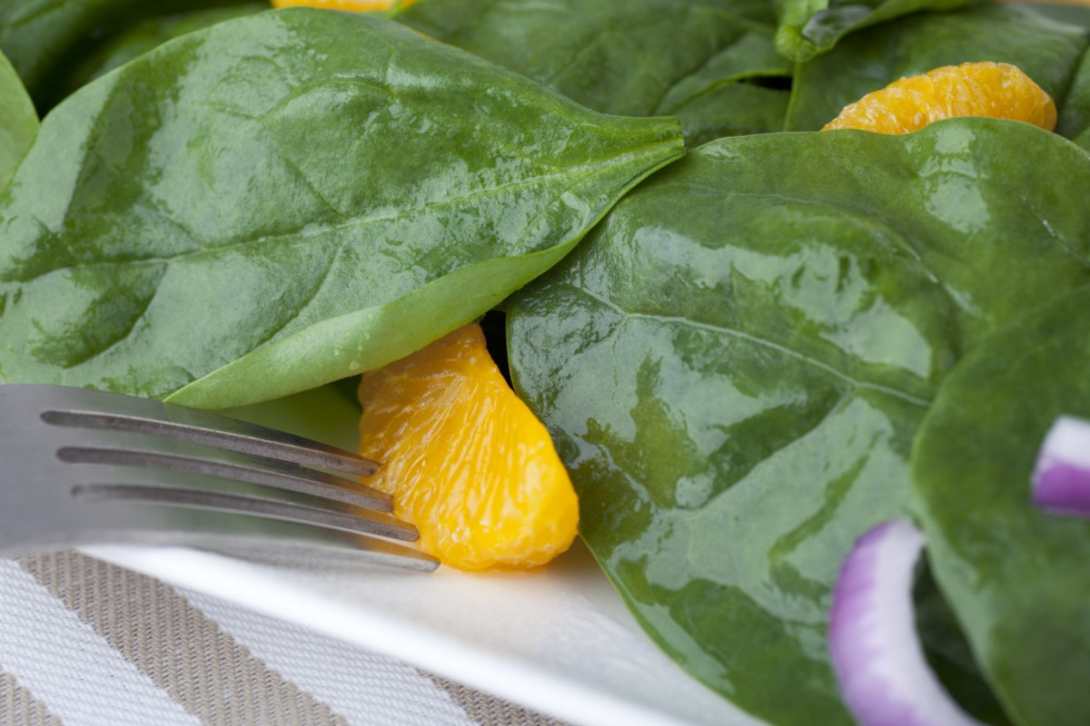 A plate with spinach and oranges