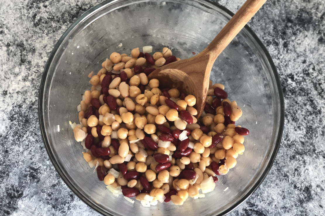 A bowl of beans with a mixing spoon