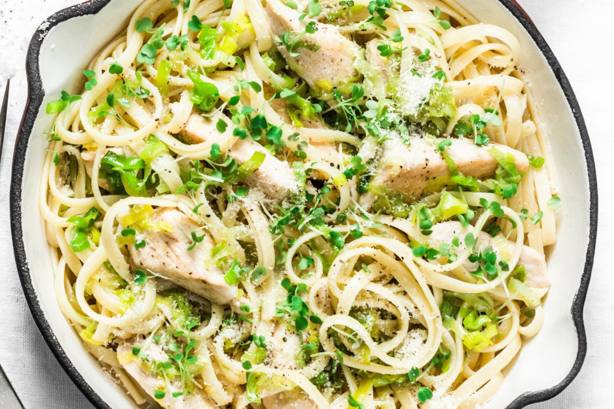 A pan of pasta with chicken and herbs