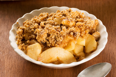 A small bowl of baked apples topped with a crumble mixture