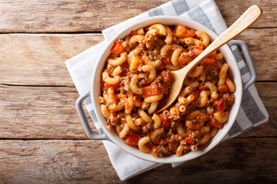 A serving bowl of goulash made with meat sauce and elbow macaroni