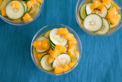 Bowls of orange slices and cucumber slices