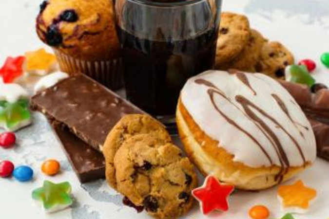 Cookies, candies, donut, muffin and a soft drink
