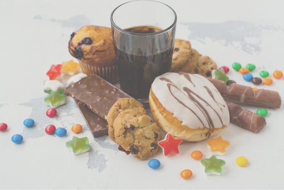 An assortment of sugary snacks and drinks including cookies, donuts and candies